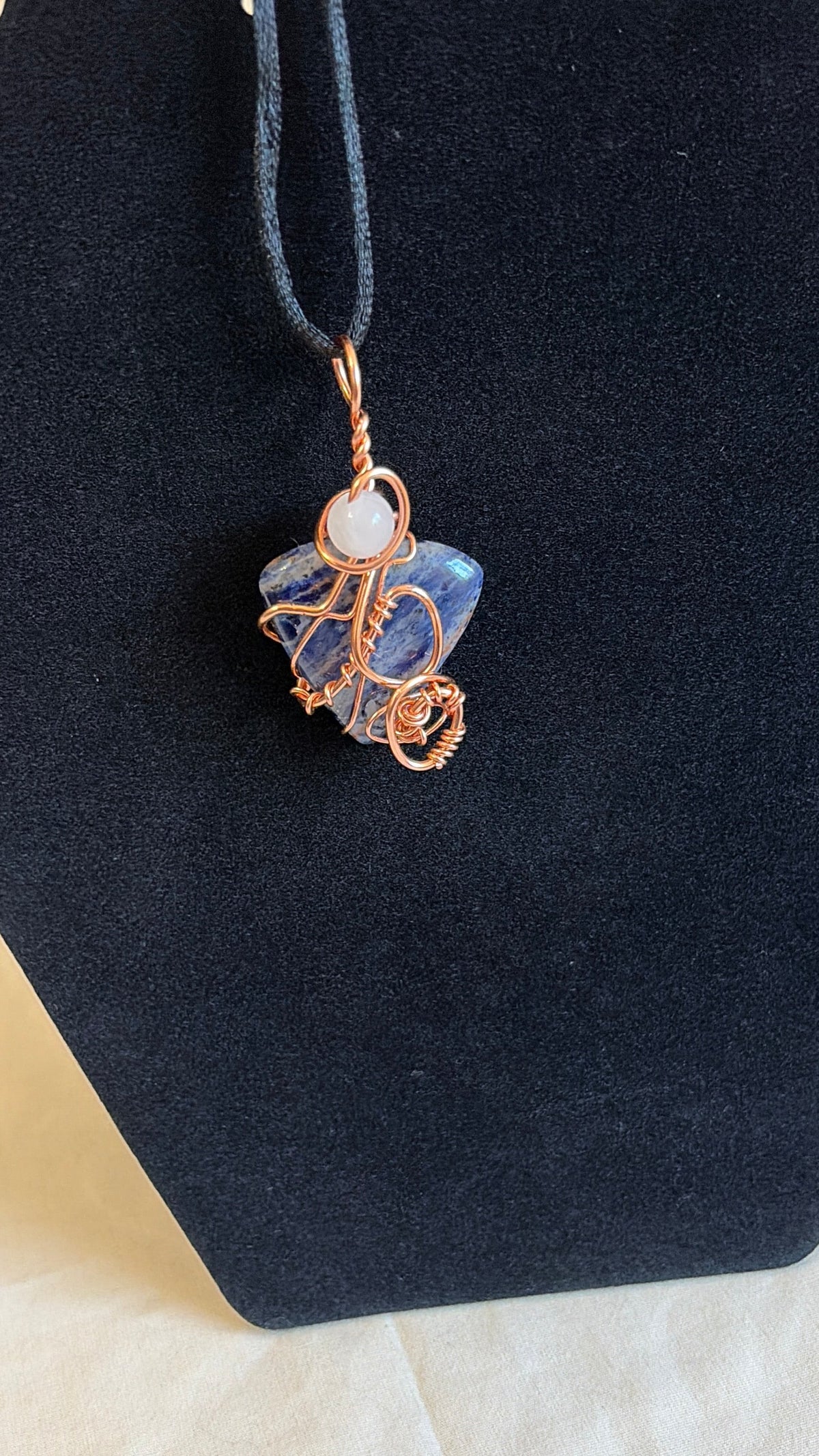 Blue-and-white sodalite pendant with rose quartz bead and copper wire wrapping